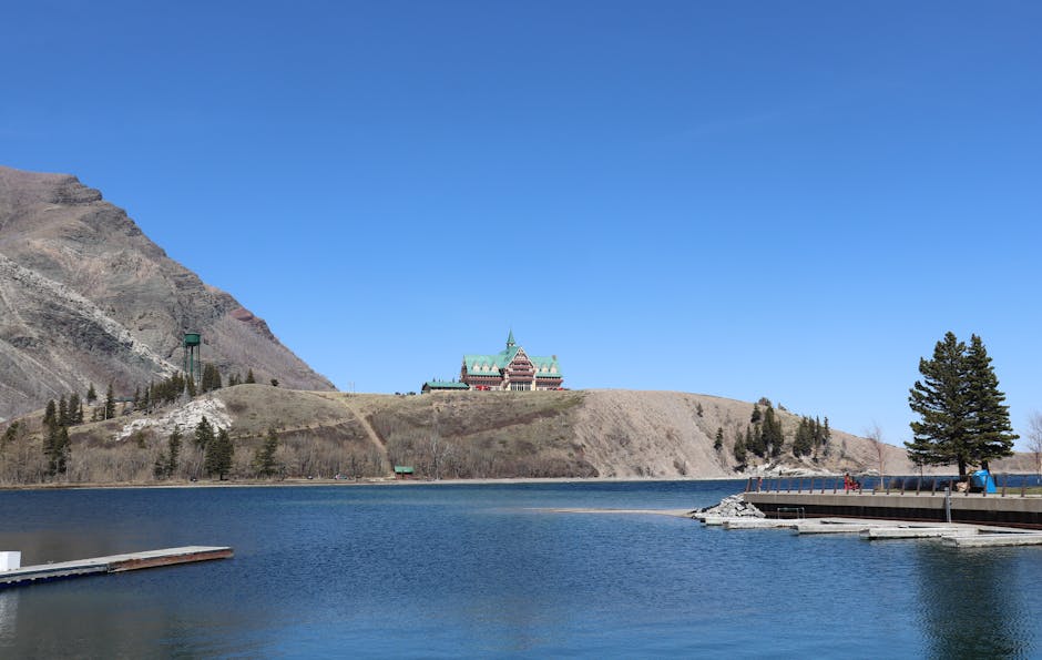 Picturesque landscape of Prince of Wales Hotel overlooking Waterton Lake with clear blue skies.